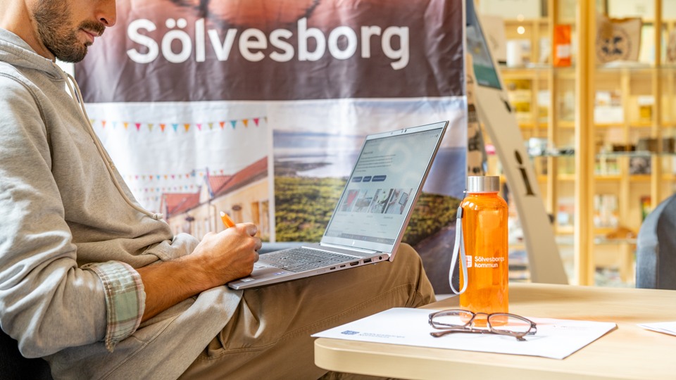 Medarbetare som sitter och jobbar vid sin bärbara dator. Foto: Sölvesborgs kommun.