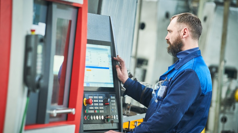 En man jobbar vid industriell miljö